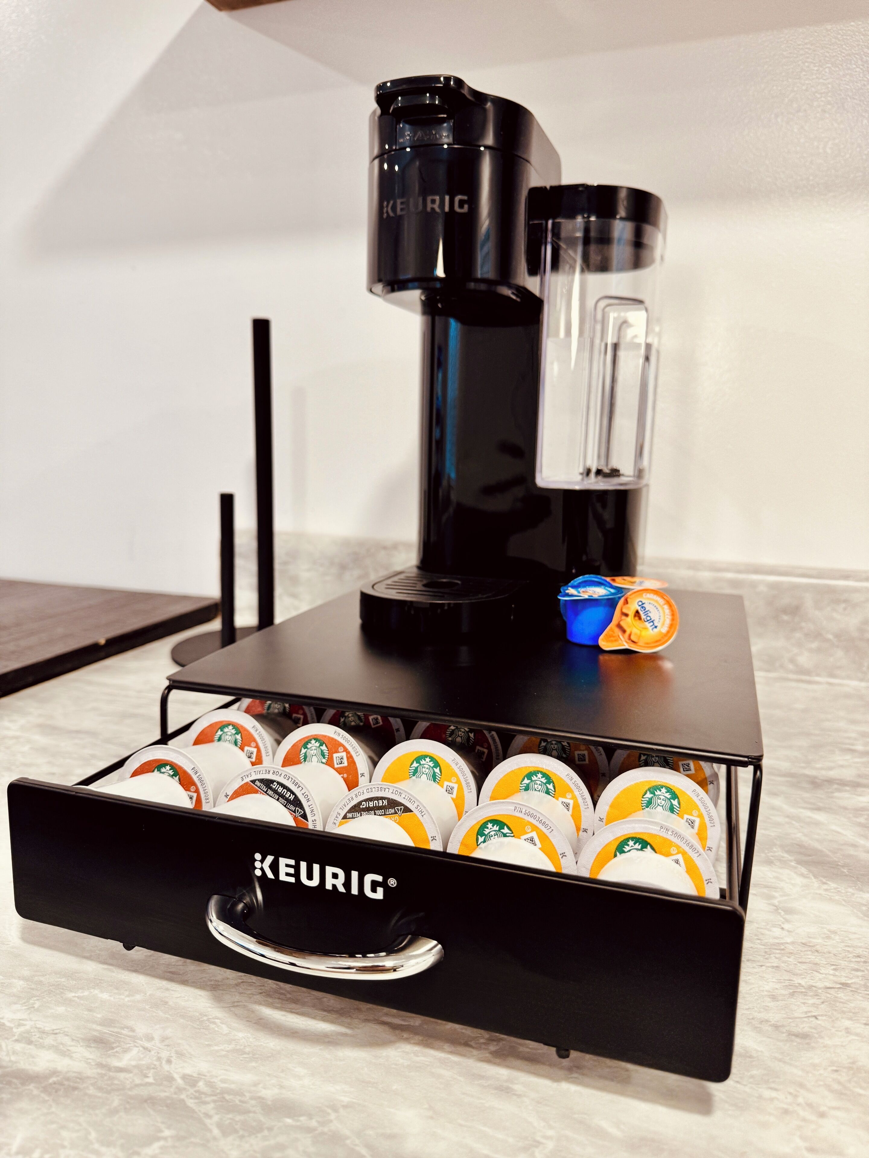 Eine Keurig-Kaffeemaschine mit einem Kaffee-Pod-Halter darunter.