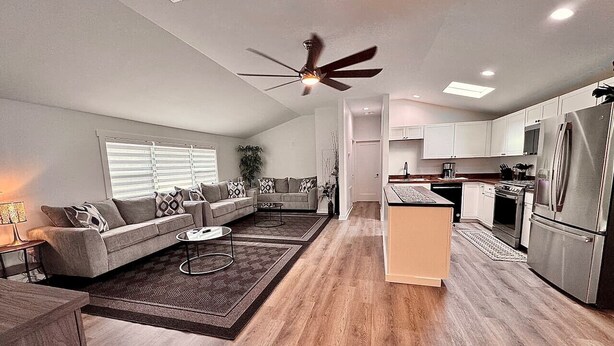 Un salon moderne avec un canapé, une table basse et un ventilateur de plafond.
