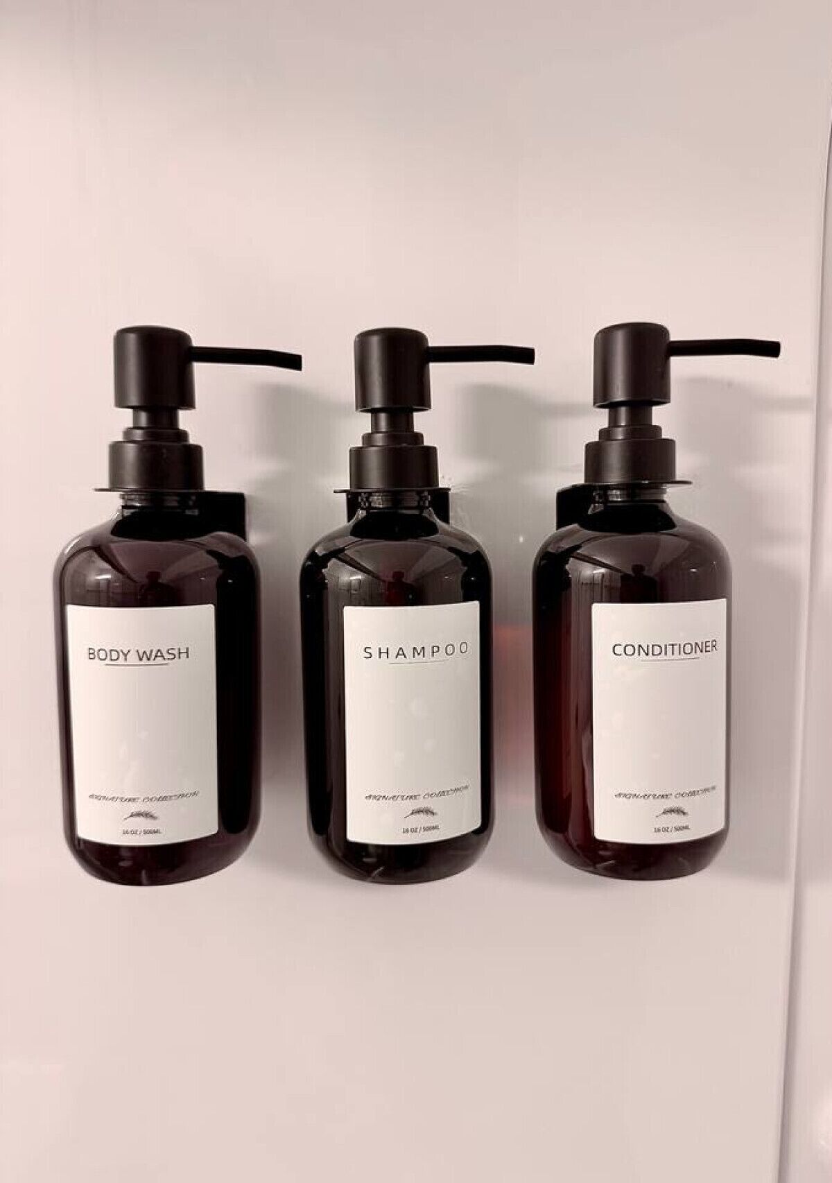 Drie flessen douchegel, shampoo en conditioner.