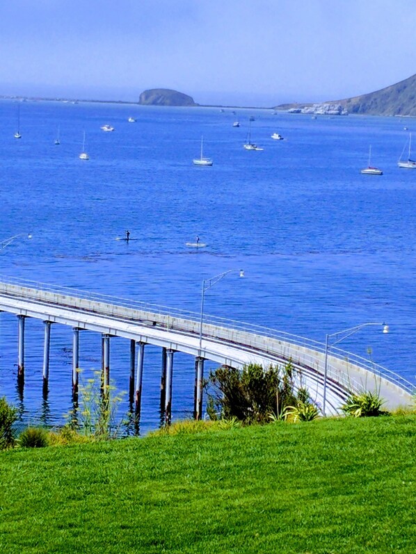 A coastal bridge with a clear view of the sea and boats.