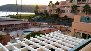 Un hotel con zona de piscina, mobiliario exterior y vistas al océano.