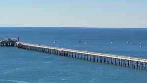 Un muelle largo que se adentra en el agua, con un pequeño edificio al final.