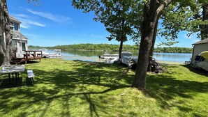A lakeside property with a dock, picnic tables, and boats. - Enjoy fall colors 2-bedroom cottage on Long Lake  Dundee. WI   on the water (Campbellsport)