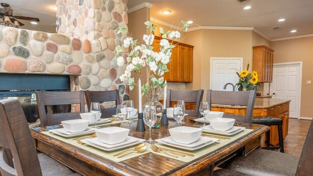 Un espace repas avec un mur en pierre, une table en bois et des chaises.