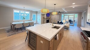 Eine moderne Küche mit einer großen Kochinsel, Holzschränken und einem eingebauten Backofen.