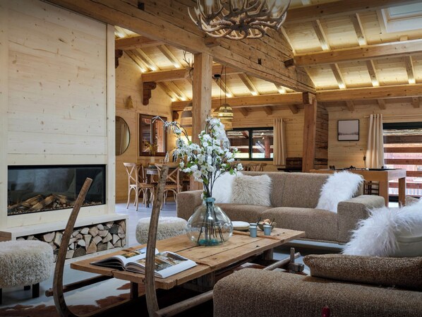 Interior acogedor de una cabaña con chimenea, muebles de madera y un comedor.