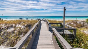 A wooden boardwalk leading to a beach with clear blue water and a sandy shore. - 6 Bedrooms | 6.5 Bathrooms | Sleeps 22 (Miramar Beach)