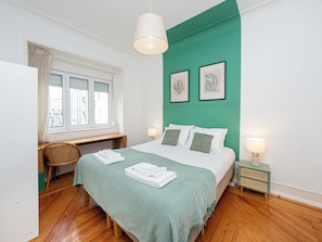 A bedroom with a bed, a desk, a chair, a window, and two wall-mounted lamps. - The Green House - Confortable for Family & Friends (Lisboa)