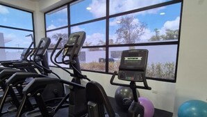 A gym with treadmills, exercise balls, and a view of the outdoors through large windows. - Caribbean home / Punta Cana /Pool, gym, playground area (Punta Cana)