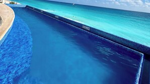 A clear blue pool with a view of the ocean and a distant shoreline. - Beautiful Caribbean Spectacular Ocean View (Cancún)