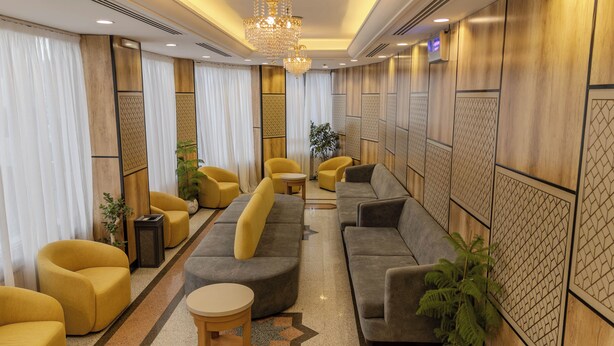 Un espace de détente moderne avec des canapés, des fauteuils et un lustre.