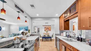 Una cocina moderna con armarios de madera, una isla central e iluminación colgante.