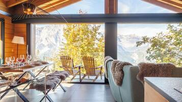 Ein modernes Interieur mit Essbereich, Sitzgelegenheiten und Blick auf die Berge.