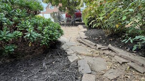 A garden pathway with mulch, stepping stones, and various plants. - Newly renovated 2 bedroom home located near the waterfront and Carnegie Library! (Munhall)