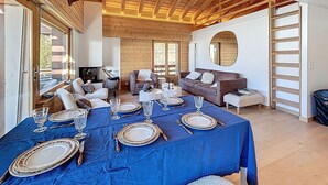Un comedor con mantel azul, techo de madera y chimenea.