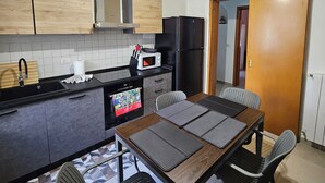 A compact kitchen with a microwave, stove, and cabinets. - A Week in Sicily - Sea breezes and history in the heart of Ortigia (Siracusa)