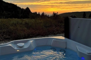 A hot tub with a sunset view.