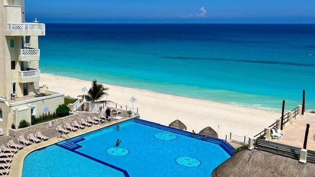 A hotel with a pool, beach, and ocean view. - Suites Luna y Sol Caribe (Cancún)