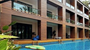 A modern building with a swimming pool, featuring a multi-story structure with balconies and large windows. - The Bihai Hua Hin (Hua Hin)