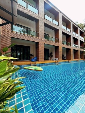 A modern building with a swimming pool, featuring a multi-story structure with balconies and large windows. - The Bihai Hua Hin (Hua Hin)