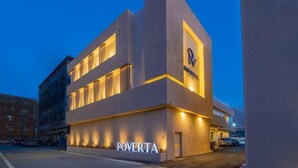 Un edificio moderno con un letrero que dice "POVERTA" a nivel de la calle.