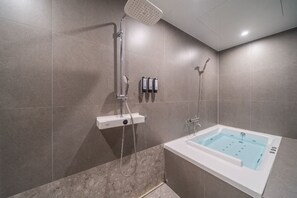 Une salle de bain moderne équipée d’une baignoire, d’un espace douche et d’un panneau de commande.