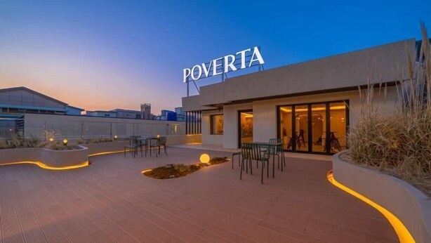 Un patio al aire libre con asientos y un edificio identificado como "POVERTA".