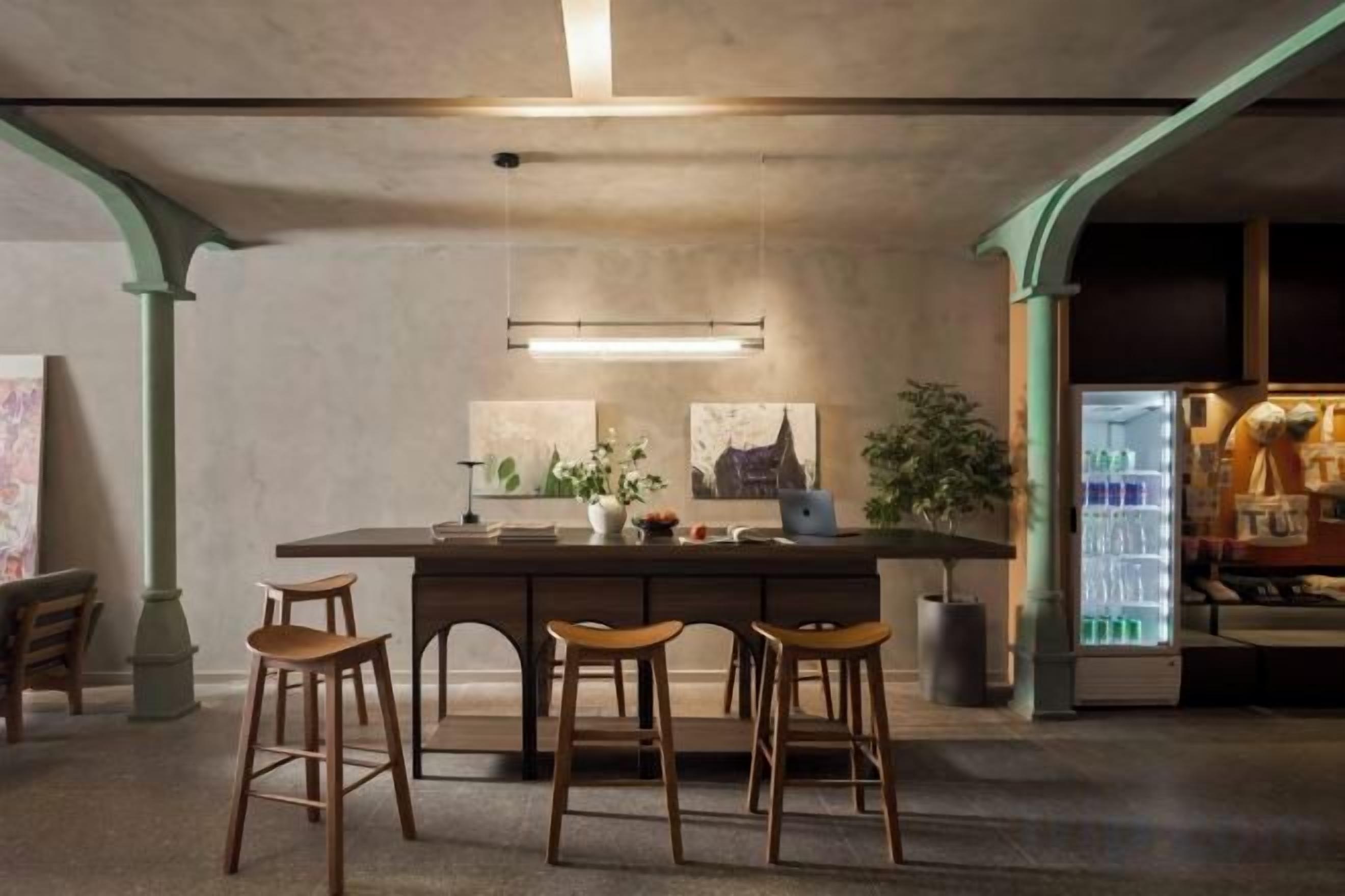 A bar area with stools, a bar counter, and a refrigerator stocked with beverages.