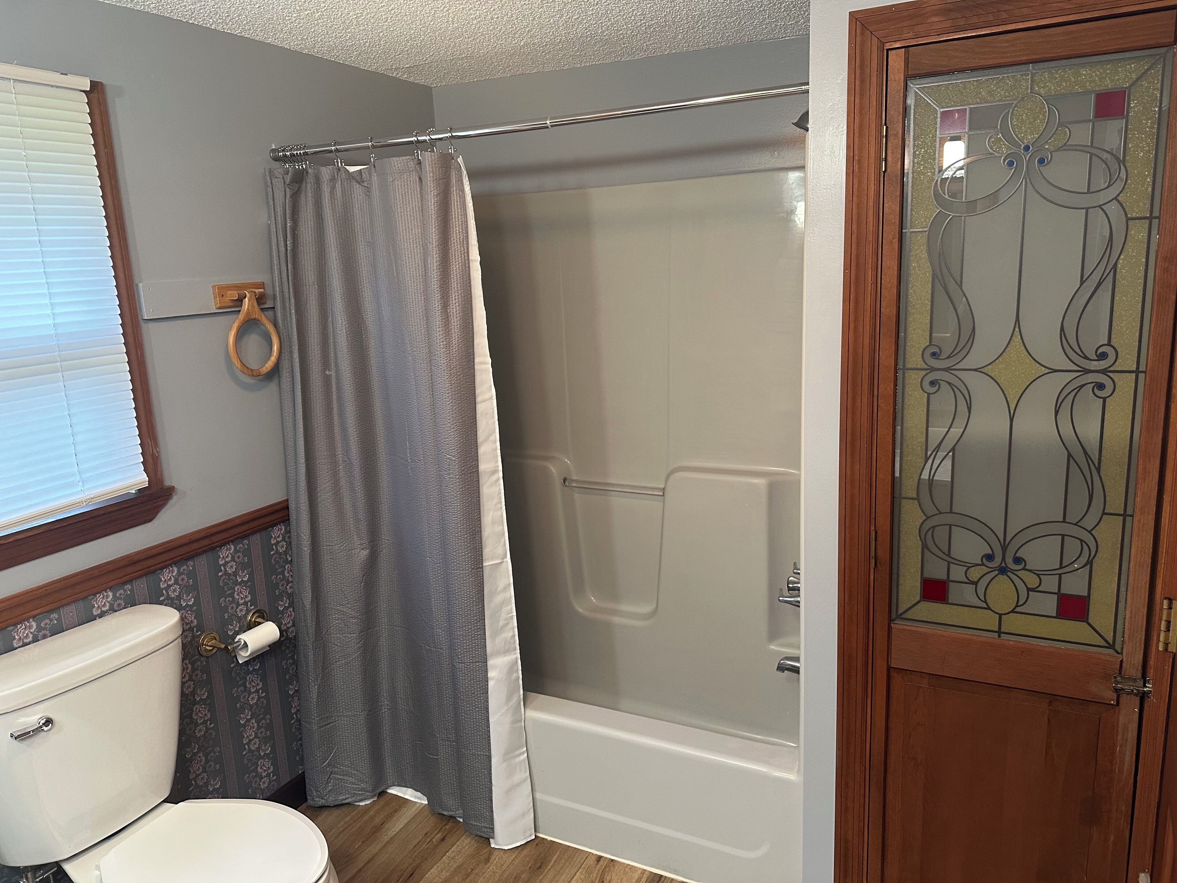Ein Badezimmer mit Dusche, Toilette und Glastür.