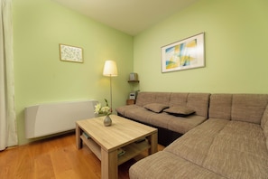 A living room with a sofa, a table with a vase, a lamp, and a radiator. - Villa Maravilla (Kvarner - Jadranovo) (Jadranovo)