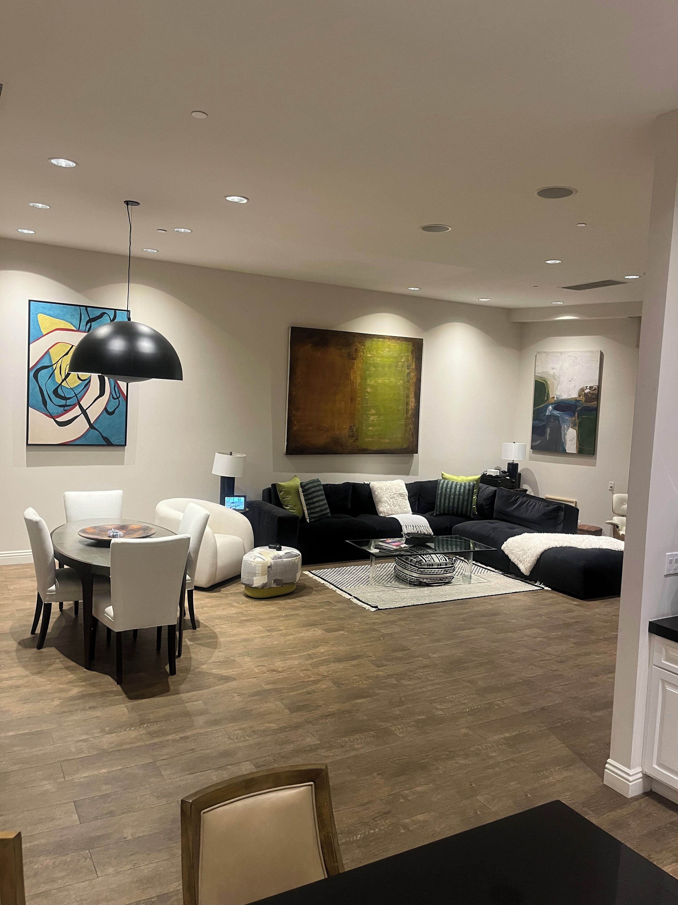 Ein modernes Wohnzimmer mit Essbereich, mit rundem Tisch, Stühlen, einer Couch und einem Couchtisch.