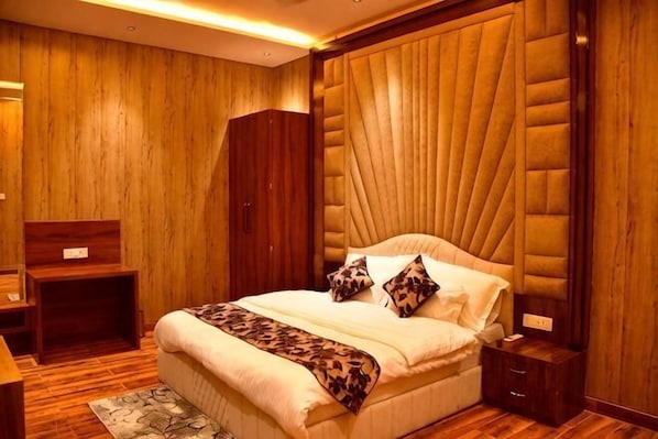 Ein Schlafzimmer mit einem großen Bett, Holzwandverkleidung, einem Kopfteil und einem Nachttisch.