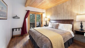 A bedroom with a large bed, wooden ceiling, and a view through a glass door. - Epic Group Stay | 3 Cabins w/ Views | Near Glacier NP, Skiing & Summer Adventures! (Columbia Falls)