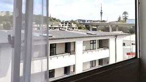 A view from a window with a modern building in the background, featuring a prominent tower. - Noa Hotel (Auckland)