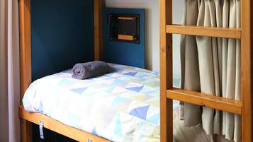 A bunk bed with a lower bunk and a top bunk, each with a pillow and a blanket.