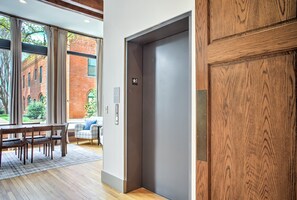An interior with a dining area, a large window, and a wooden door.