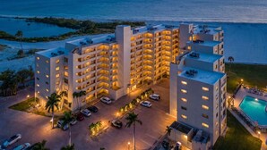 A hotel with multiple floors, a swimming pool, and a view of the ocean. - Beachside Bliss with Stunning Gulf Views & Resort Amenities – Lander's Sunset Lagoon - Roelens (Fort Myers Beach)