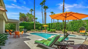 A backyard with a swimming pool, outdoor furniture, and palm trees. - Desert Gem - Bold Design, Poolside Fun, Spa, BBQ & Views (Palm Springs)