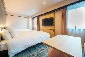 Habitación de hotel con cama, televisor montado en la pared y una mesita.