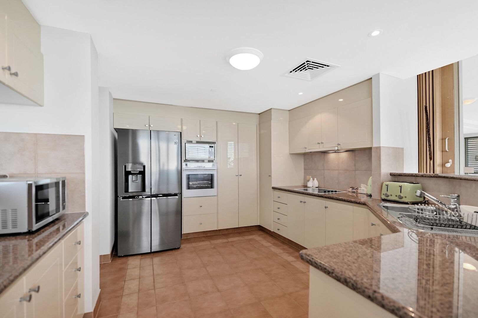 A modern kitchen with stainless steel appliances, a built-in oven, and a microwave.