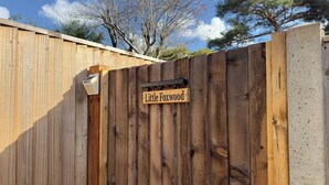 Une clôture en bois sur laquelle est accrochée une pancarte indiquant « Little Foxwood ».