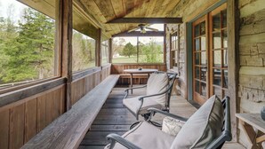 A wooden porch with a table and chairs, a ceiling fan, and a view of trees. - Hummingbird's Rest - Wine Country Cabin Retreat (Dyke)
