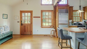 A spacious kitchen with wooden beams, large windows, and a bar area. - Hummingbird's Rest - Wine Country Cabin Retreat (Dyke)