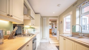 Una cocina moderna con una isla central, horno empotrado y ventana con vistas al exterior.