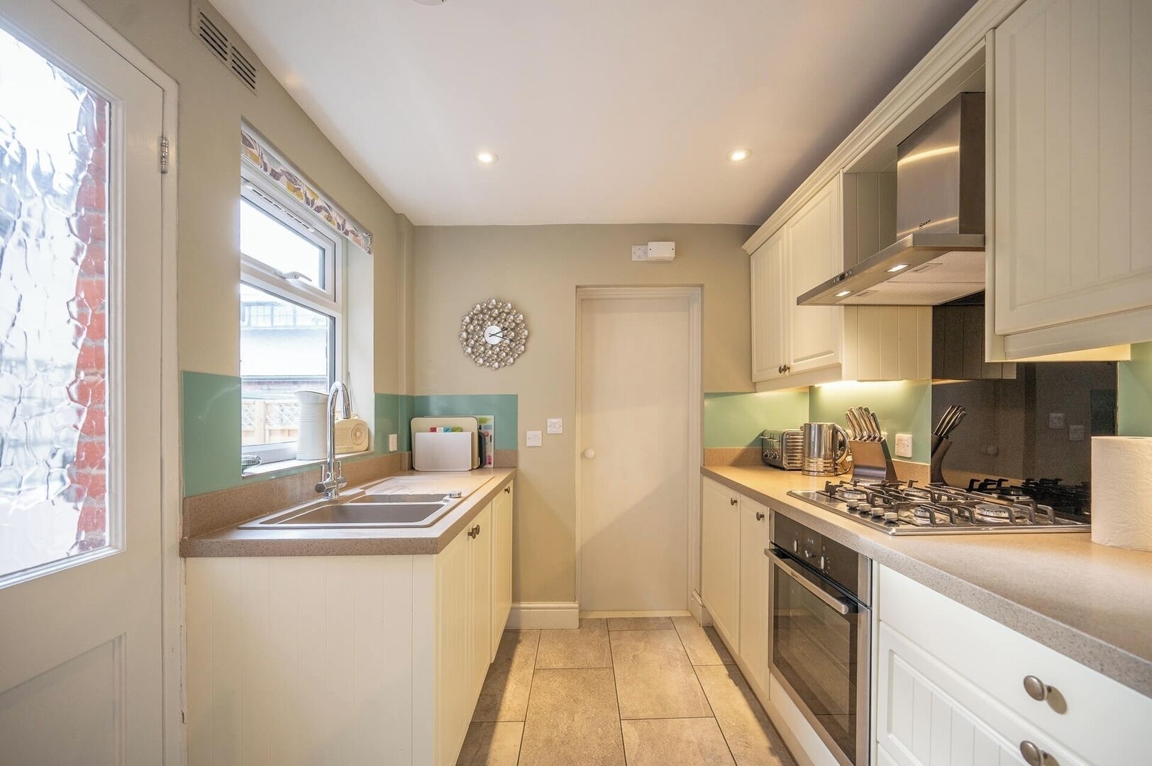 A compact kitchen with a sink, stove, and cabinets.