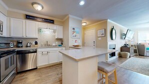 A modern kitchen with white cabinetry, stainless steel appliances, and a central island. - Shared Pool, Hot Tub, Pet Friendly (Port Aransas)