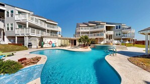 A residential complex with a swimming pool, multiple balconies, and a lifeguard station. - Shared Pool, Hot Tub, Pet Friendly (Port Aransas)