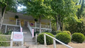 Un edificio con un letrero que dice "Blossom Hill Casita" y una escalera que lleva a un porche.