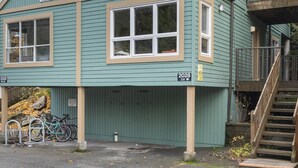 Ein zweistöckiges Gebäude mit grüner Fassade, einem Balkon im oberen Stockwerk und einer Treppe zum Eingang.