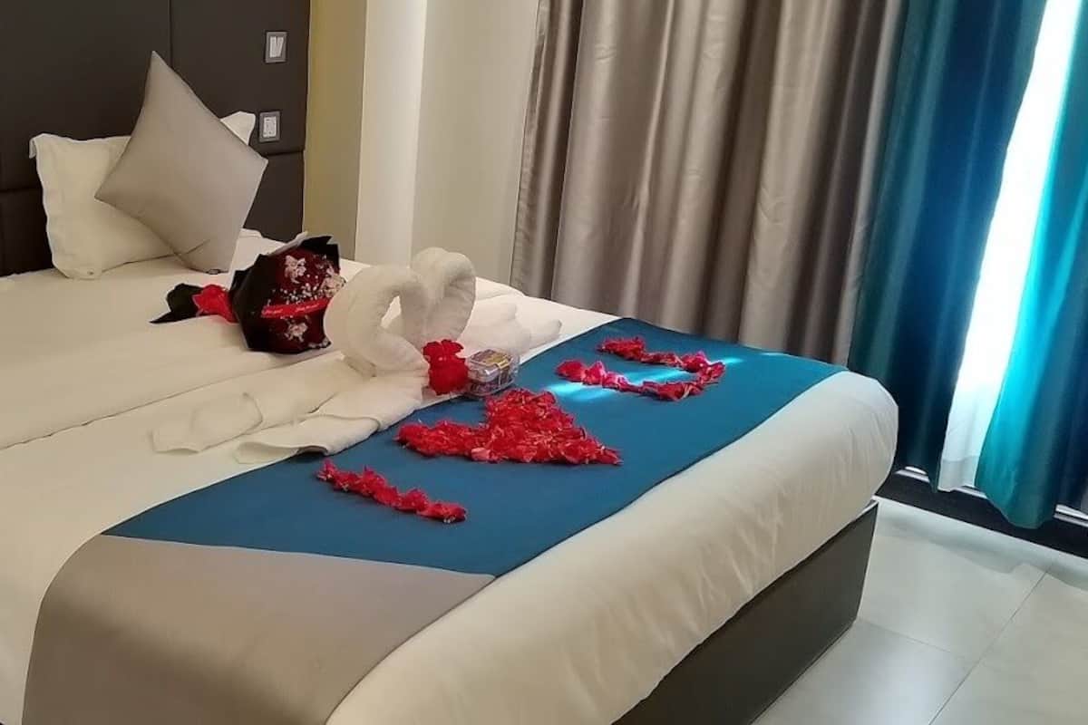A neatly made bed with white bedding and a blue accent.
